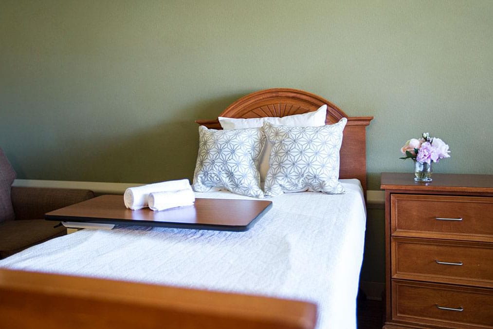 A wooden bed with white pillows