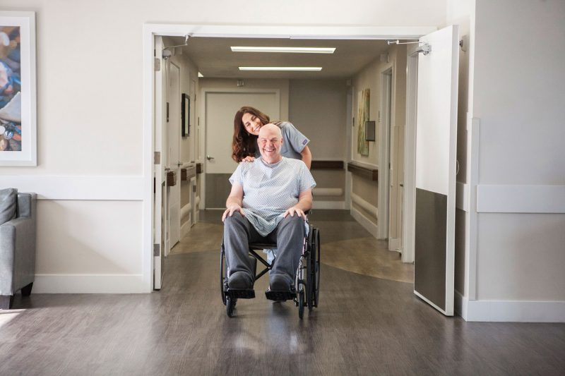 nurse bring patient to his room in a wheelchair
