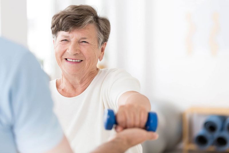 woman in physical therapy with weights