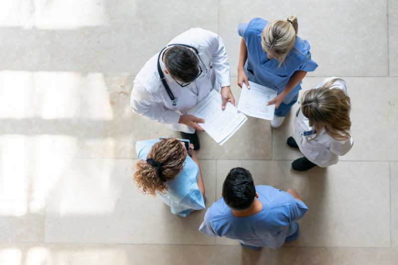 Doctors and Certified Nurses gathering to go over patient files