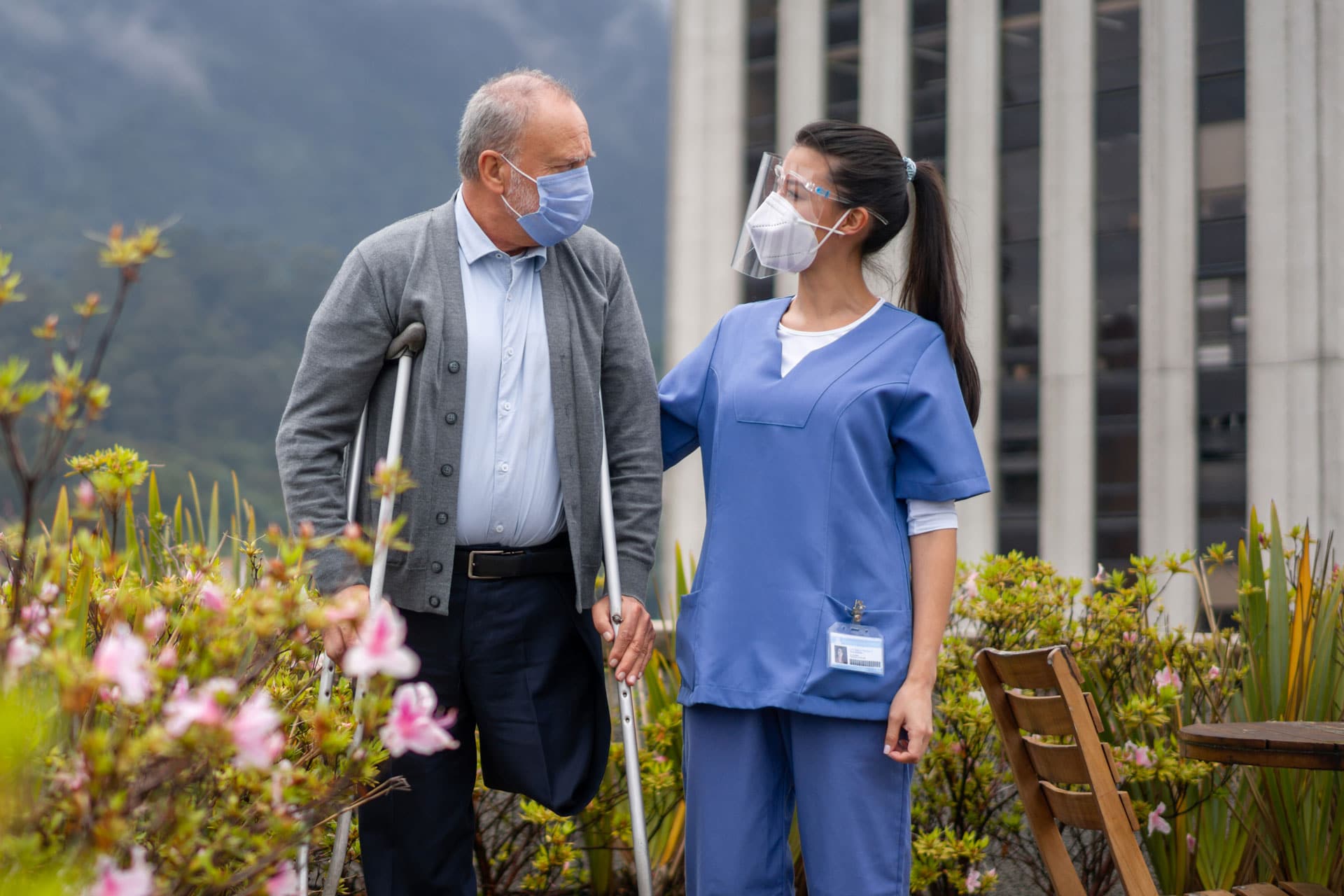 certified nurse talking an elderly patient on a walk outdoors