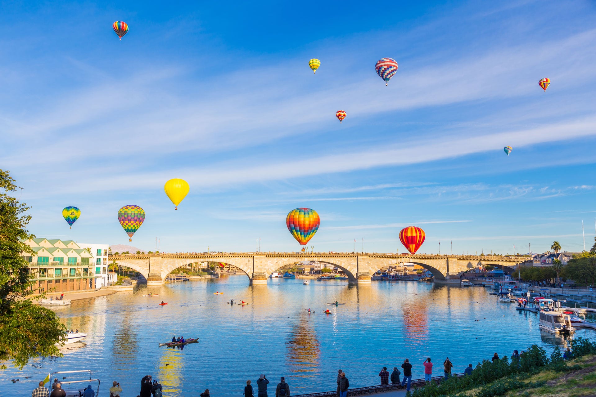 hot air balloons fill the air above water