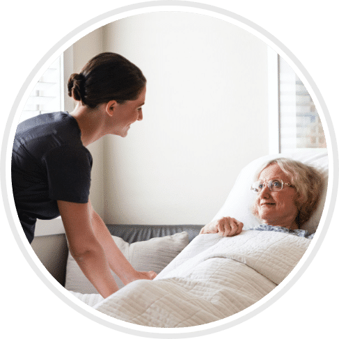 nurse tucking patient into bed