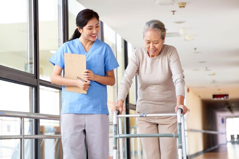 skilled nurse seeing elder patient make progress with walker