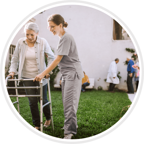 licensed practical nurse assisting an elder woman with her walker
