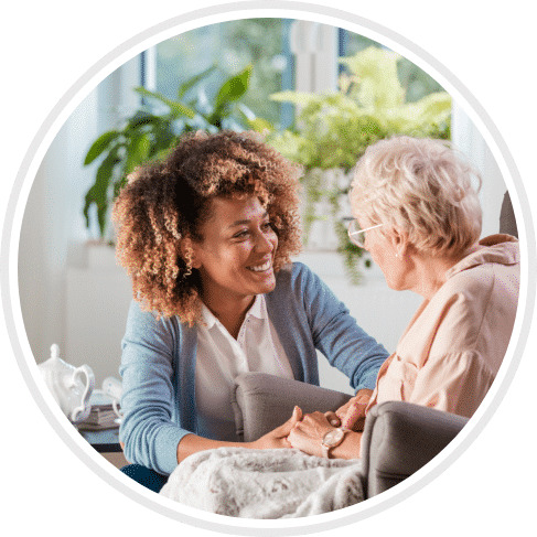 caretaker smiling at patient in wheelchair