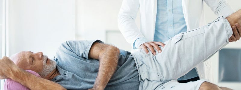 patient getting hip stretch from physical therapist