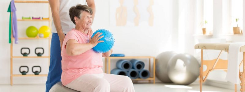 Older patient receiving physical therapy from a skilled nurse at an assisted living facility