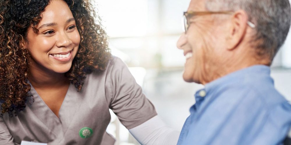 Skilled Nurse Talking With Elderly Male Patient
