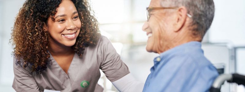 skilled nurse talking with elderly male patient