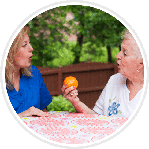 skilled nurse assisting female patient with speech therapy