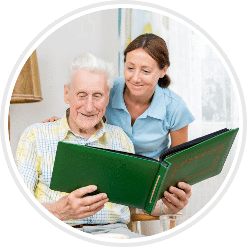 elder man looking at photos to help with his Alzheimer's