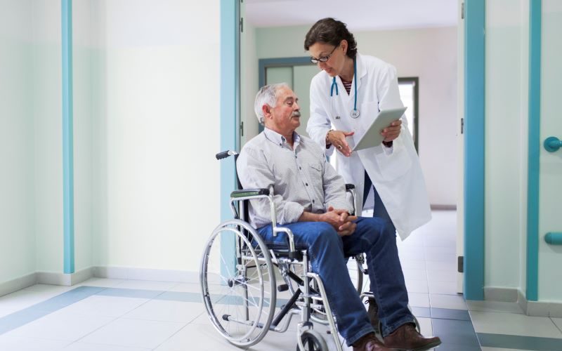 elder man with his doctor getting discharged from hospital