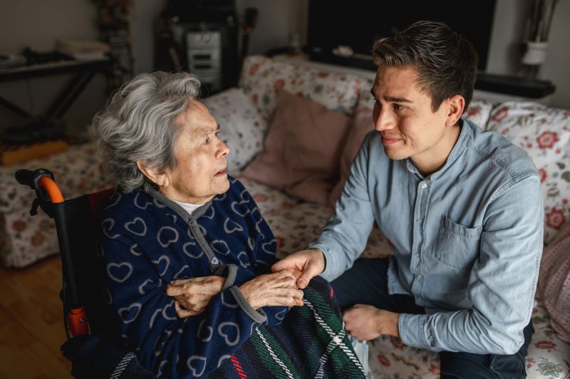 elderly dementia woman unsure of who the nice male visitor is