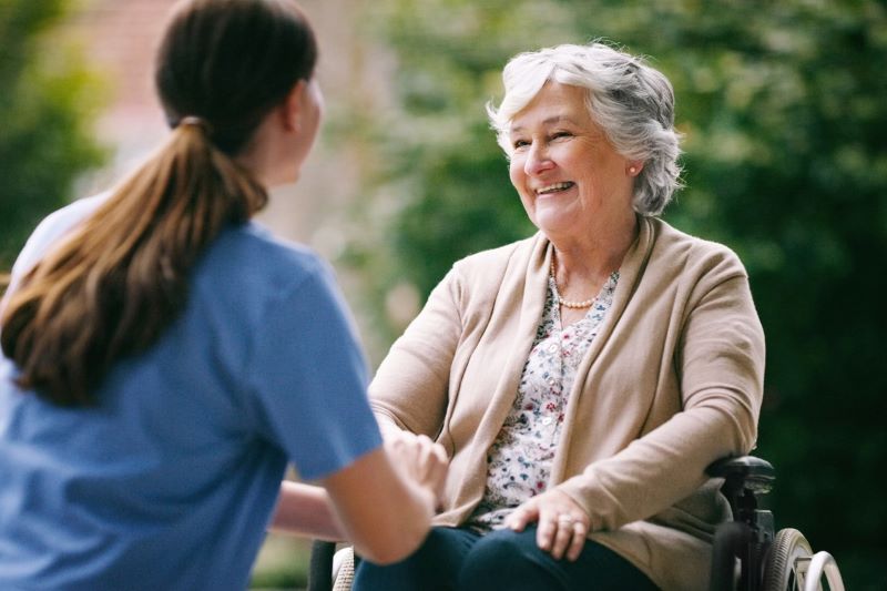 registered nurse taking female patient on a stroll in a wheelchair