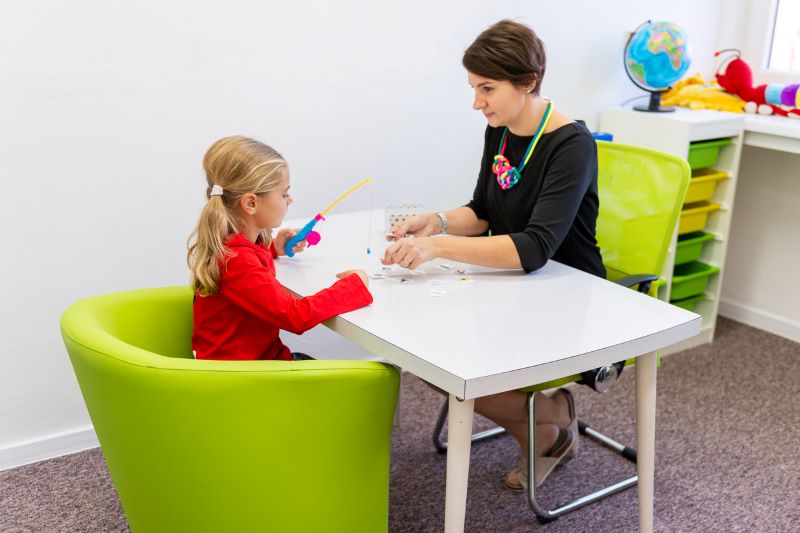 Girl In Child Occupational Therapy Session Doing Playful Exercises