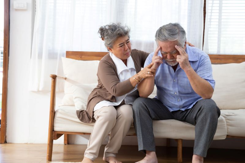 elder couple sitting together while the man is suffering from sundown syndrome