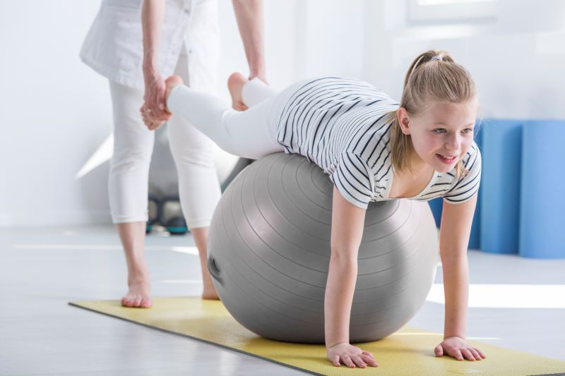 young girl on a yoga ball for occupational therapy