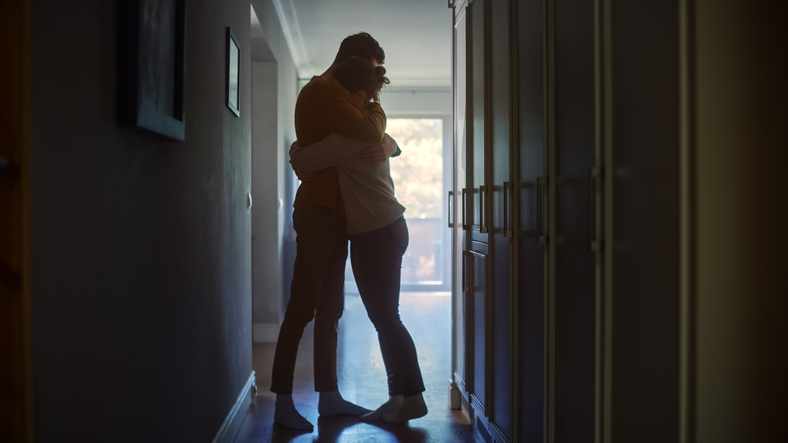 Sad Couple Embracing, Comforting Each Other In Difficult Times. Family Overcoming Difficulties Together, Tender Moment. Atmosphere Of Sadness And Tragedy. Moment Of Human Drama