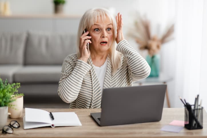 urprised shocked mature woman talking on mobile phone