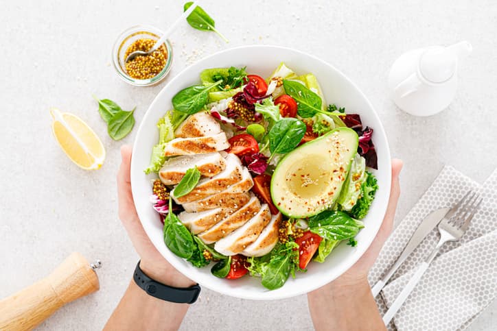 Adult holding bowl of healthy salad 