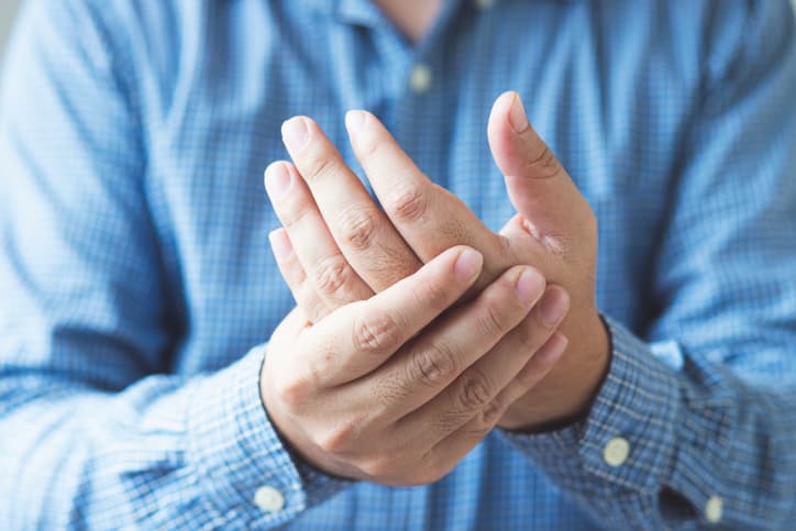 Man Experiencing Joint Pain In Wrist And Hands