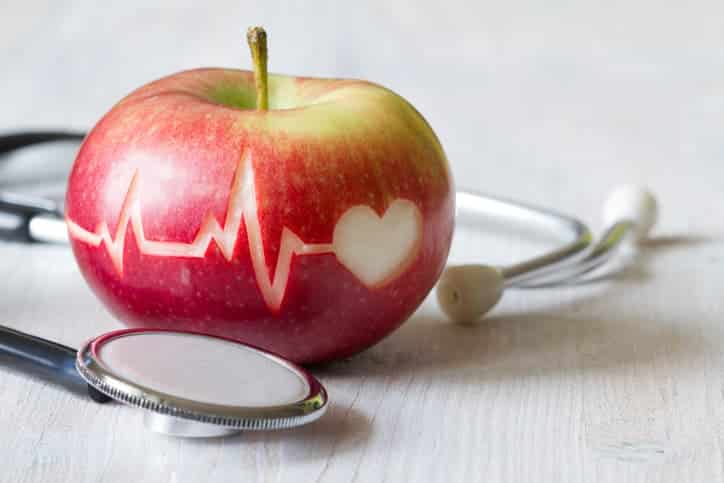 Heartbeat line on red apple and stethoscope
