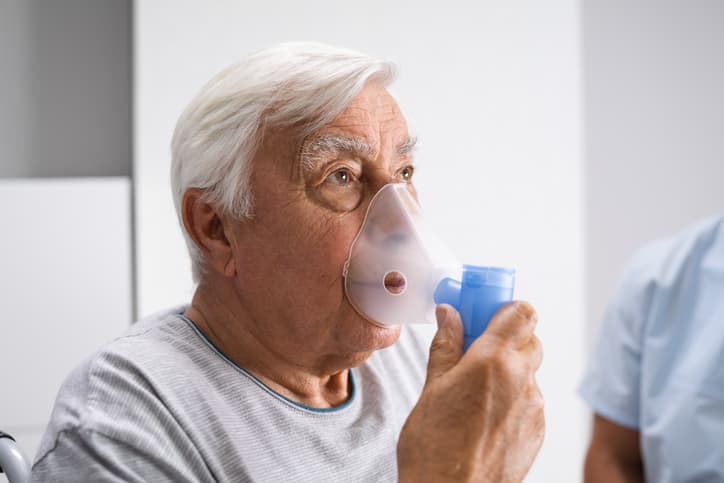 Elderly man using oxygen mask
