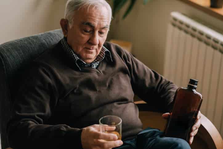 older man drinking at home