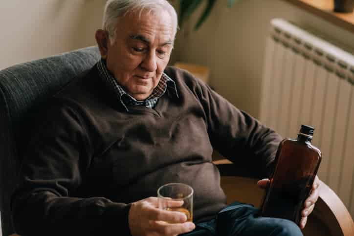 Older Man Drinking At Home