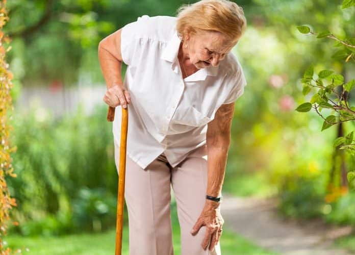 elderly woman with cane in pain