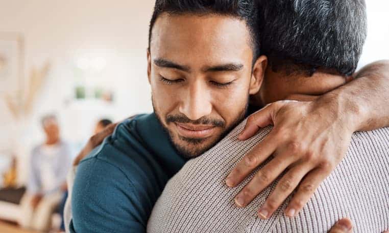 son hugging elderly dad