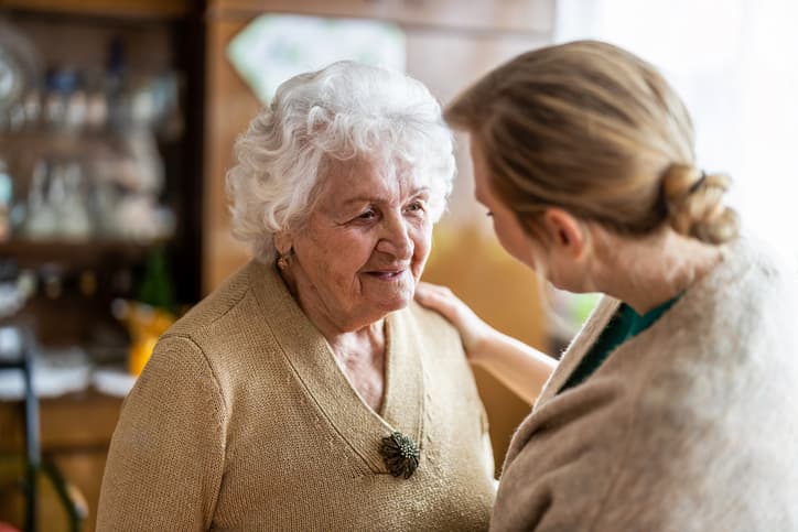 elderly woman speaking with woman