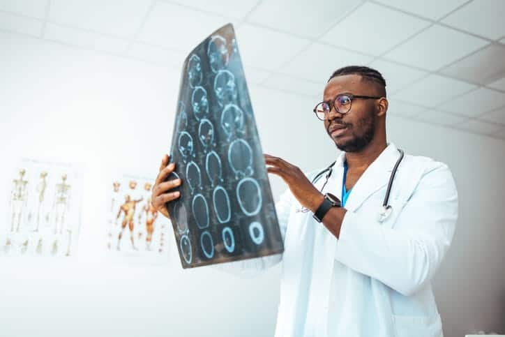 A doctor reviewing brain scans of a patient with mixed dementia.