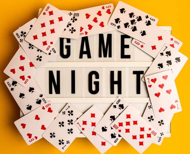 A Sign Stating, &Quot;Game Night,&Quot; That Is Surrounded By Playing Cards.