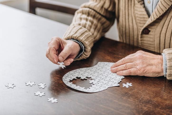 An Elderly Man Doing A Puzzle.