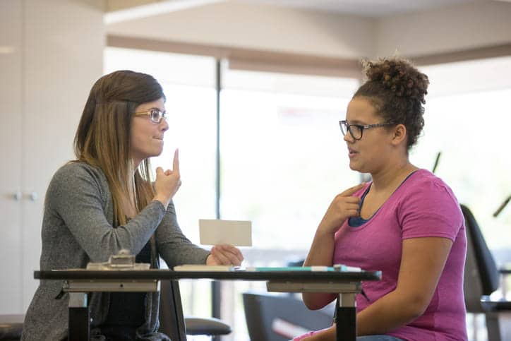 A speech therapist works with her adult patient.