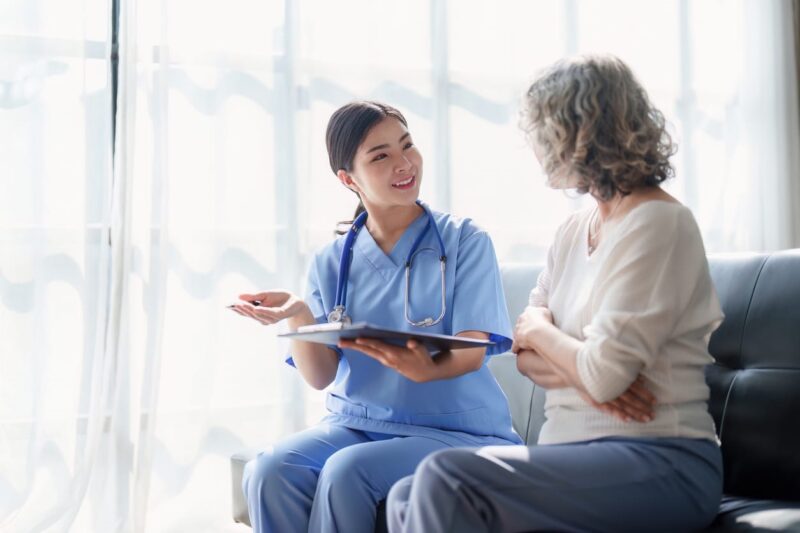 A Certified Nursing Assistant helping a patient with their paperwork.