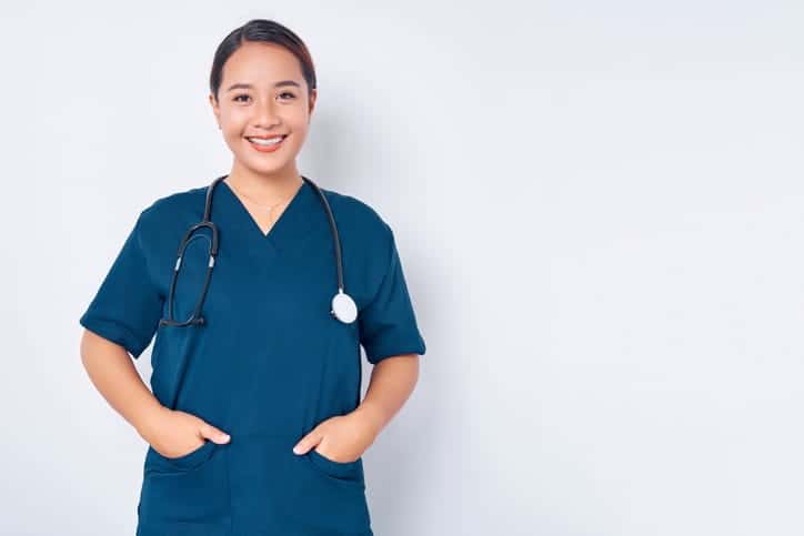 A CMA in blue scrubs is smiling for a photo.