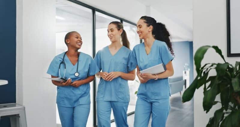 A CMA in blue scrubs is smiling for a photo.
