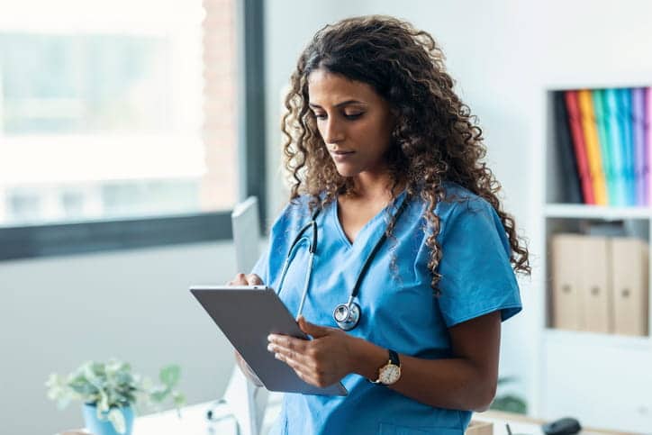 A SNF nurse reviewing her schedule on a tablet.