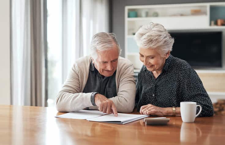 An elderly couple reviewing the costs of assisted living. 