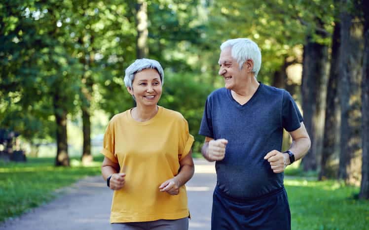 Two elderly people going on a brisk walk together. 