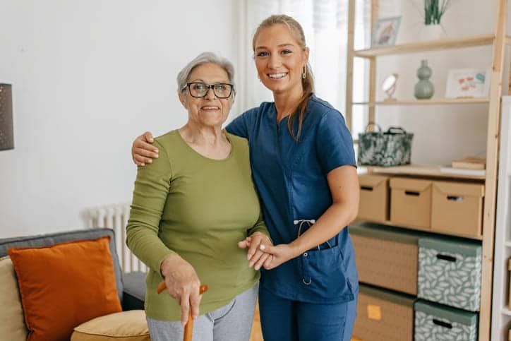 A Nurse Hugging And Smiling With An Elderly Patient. 