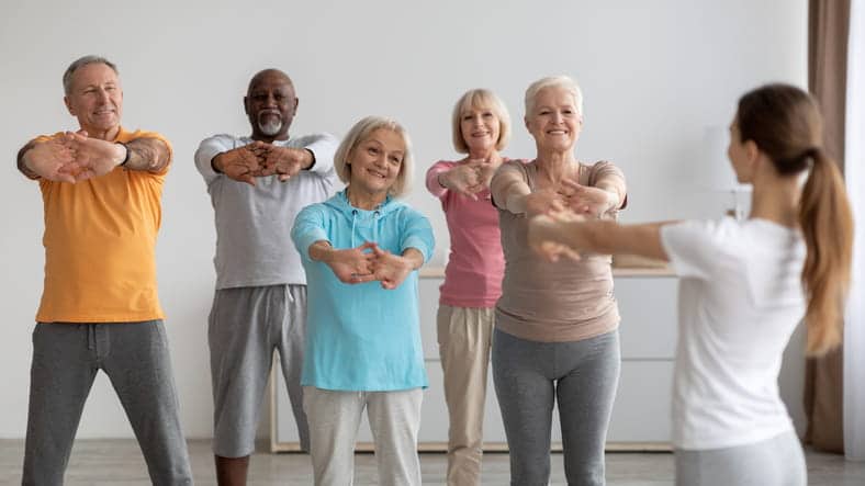 A group of senior stretching together in a work-out class. 