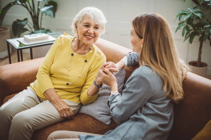A woman speaking with her elderly mother about assisted living.
