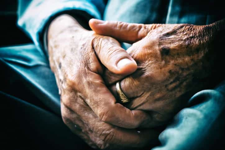 A closeup of an elderly man's hands that are covered in spots. 