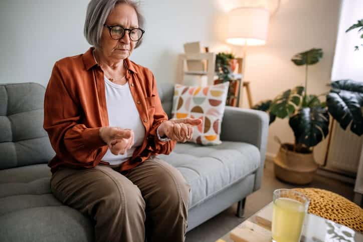 An Elderly Woman Experiencing Wrist Pain Due To Arthritis. 