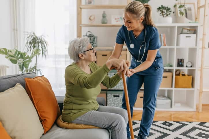 A nurse at an assisted living facility helping their elderly patient. 