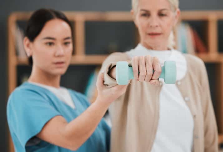 An occupational therapist assisting a patient in an assisted living facility.